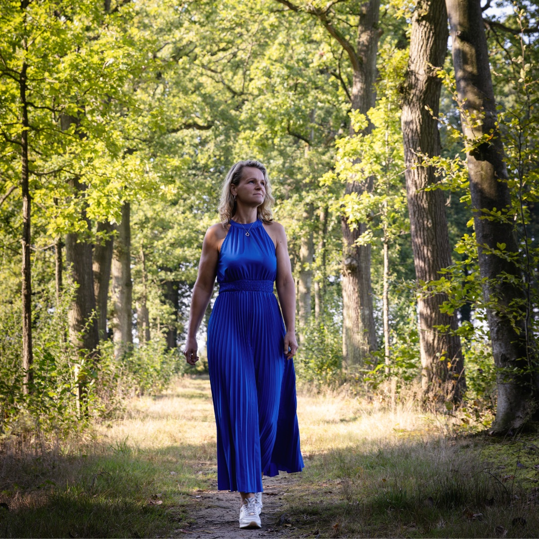 Esther in een blauwe jurk in het bos